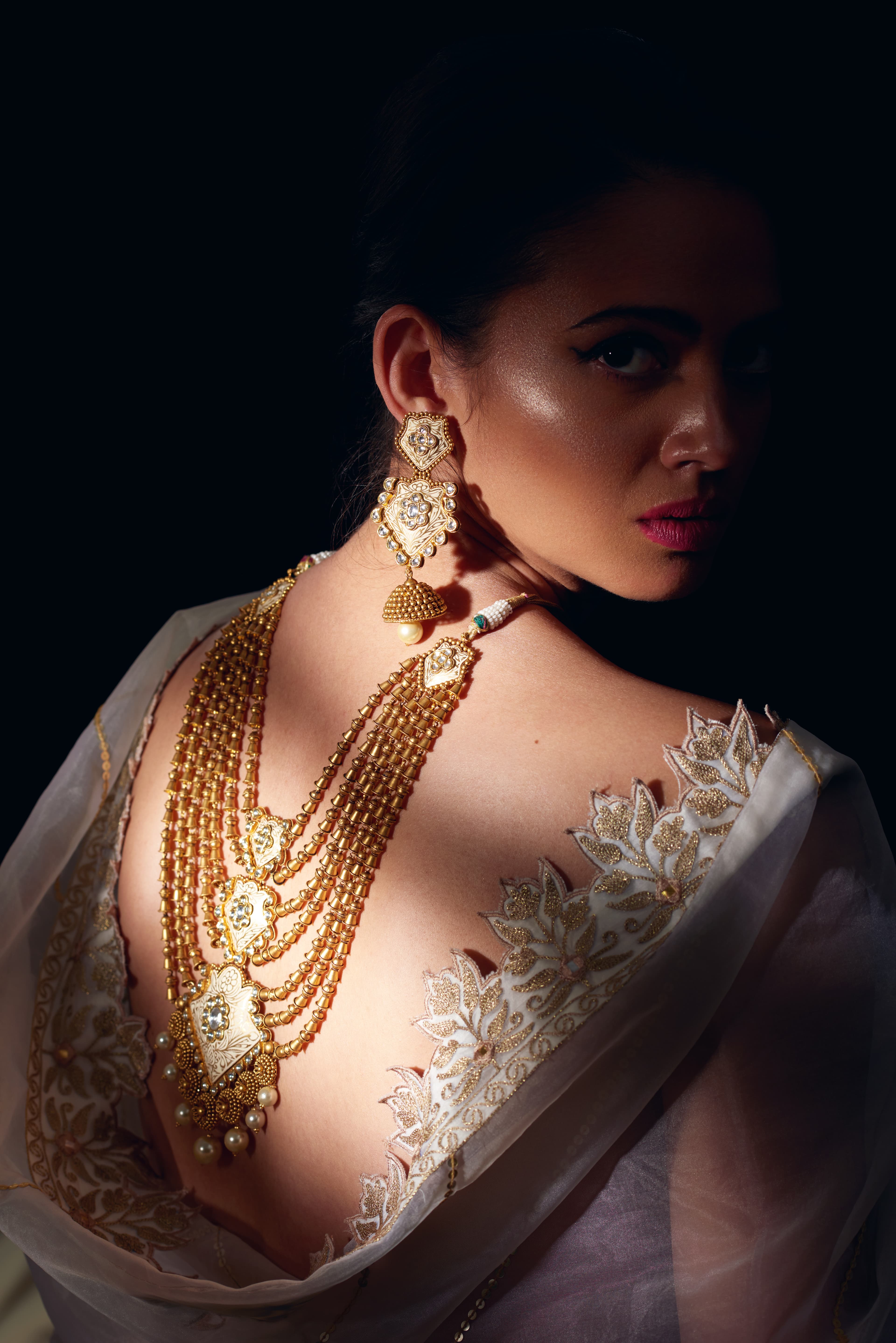 Jewellery campaign portrait with gold rani-haar over a backless white saree