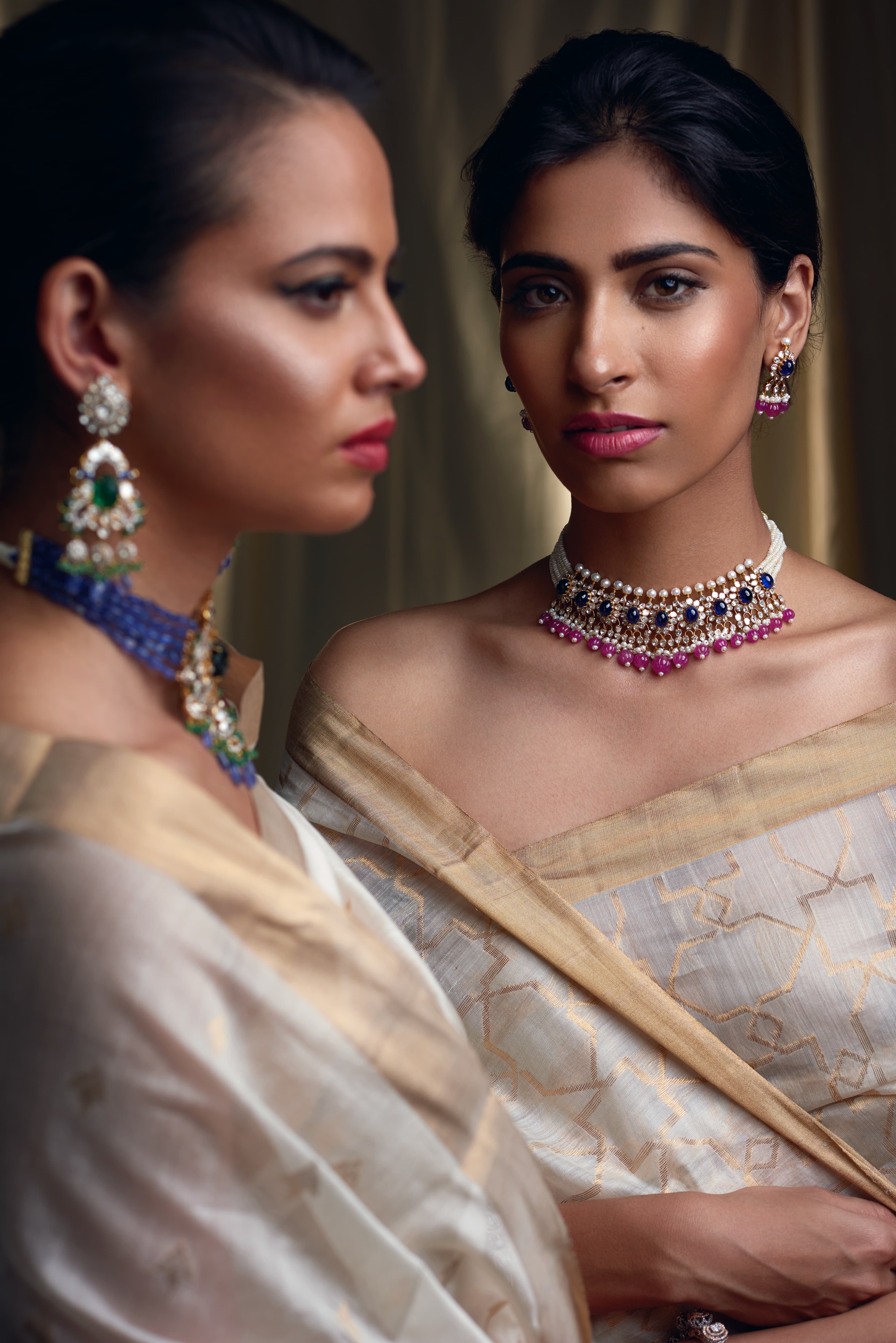Two models in cream-gold saris for a jewellery campaign